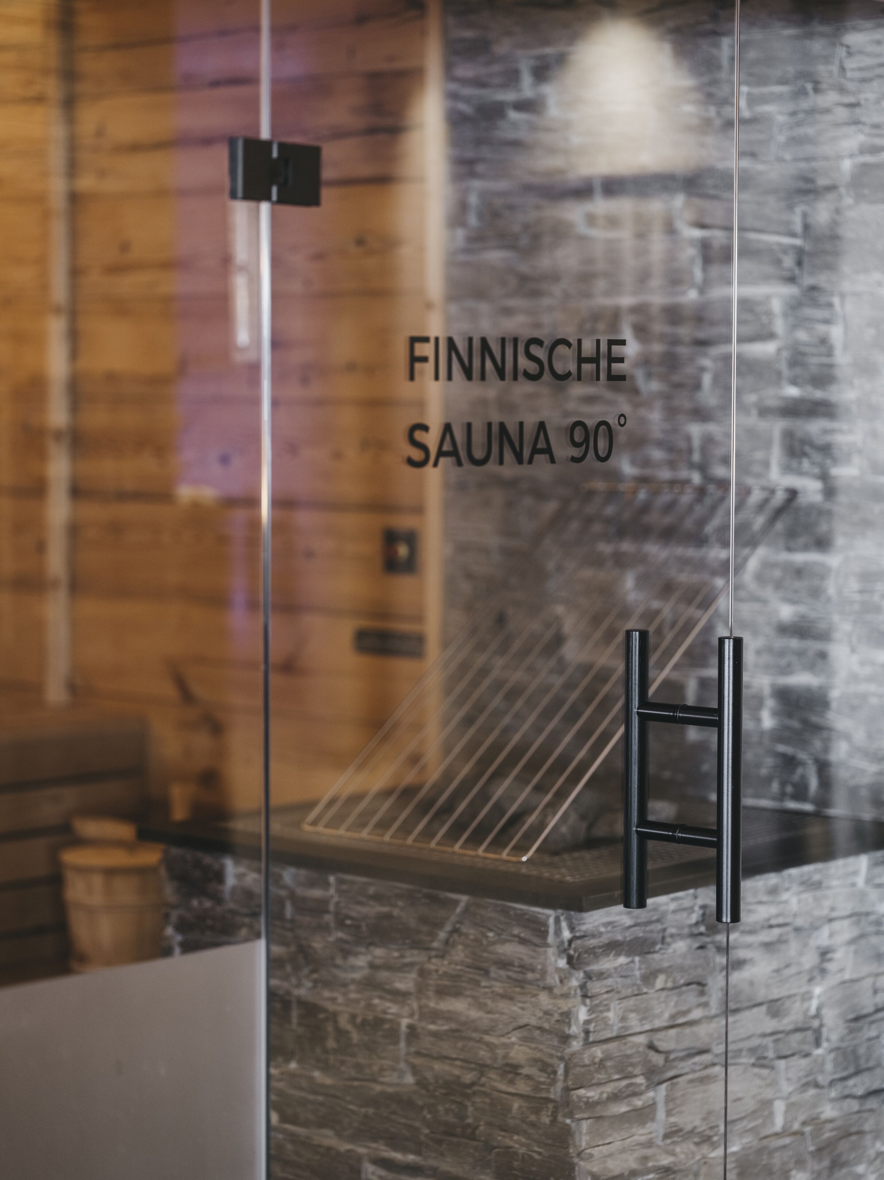 Een sauna met een stenen muur en een metalen rek.