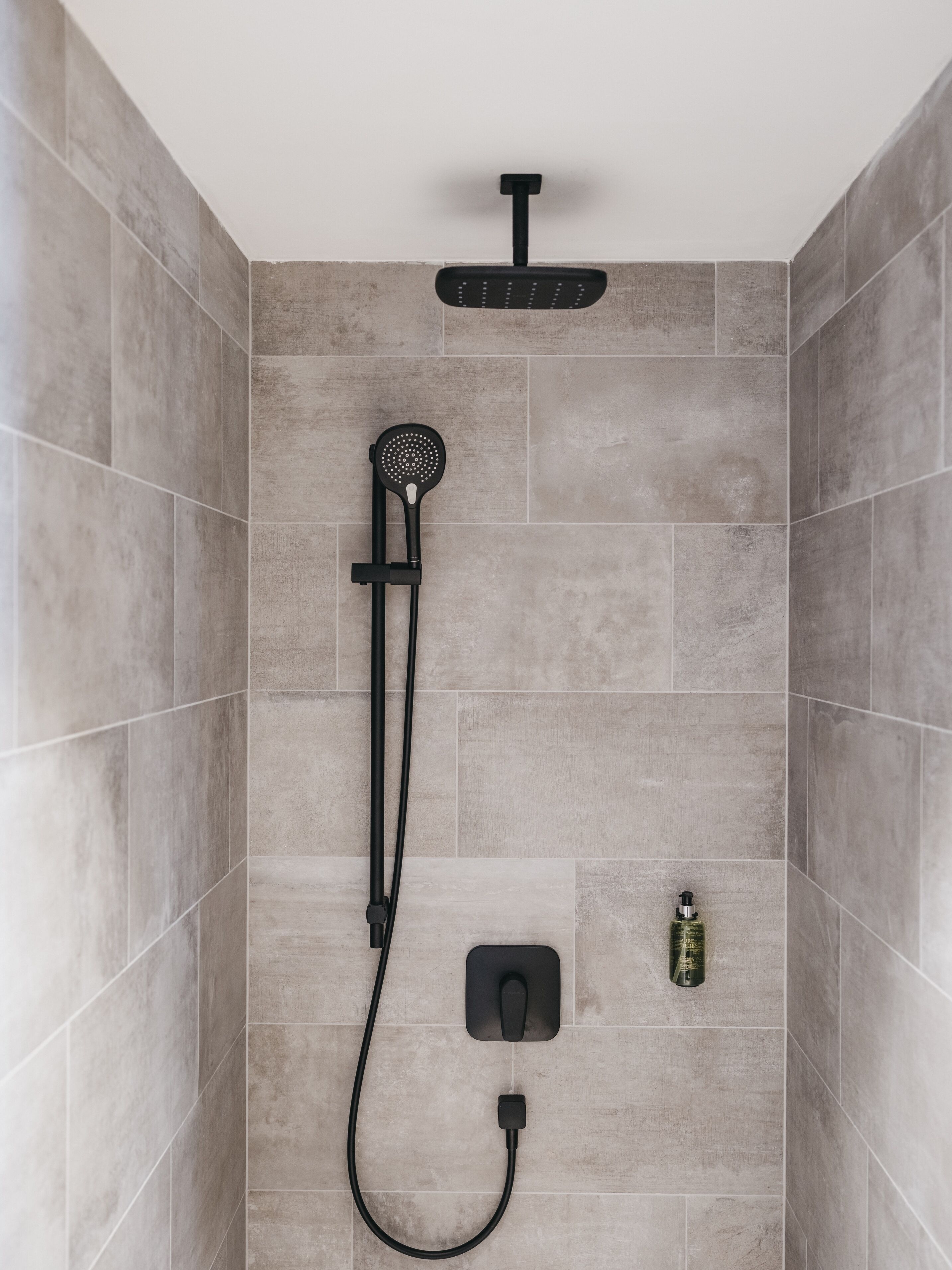 Eine Dusche mit Handbrause und einer fest installierten Bedienung.