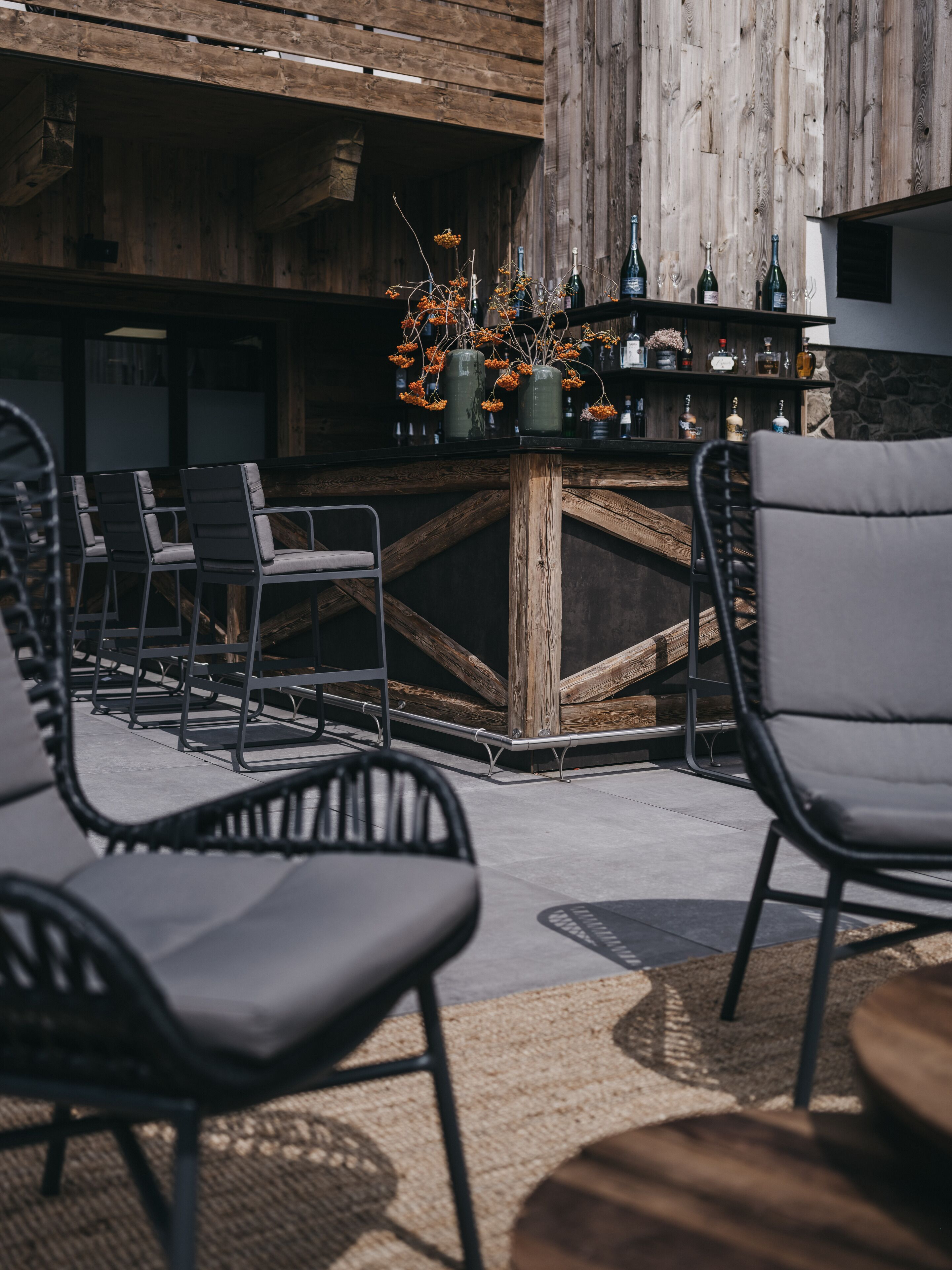 An outdoor seating area with metal chairs and a bar counter.
