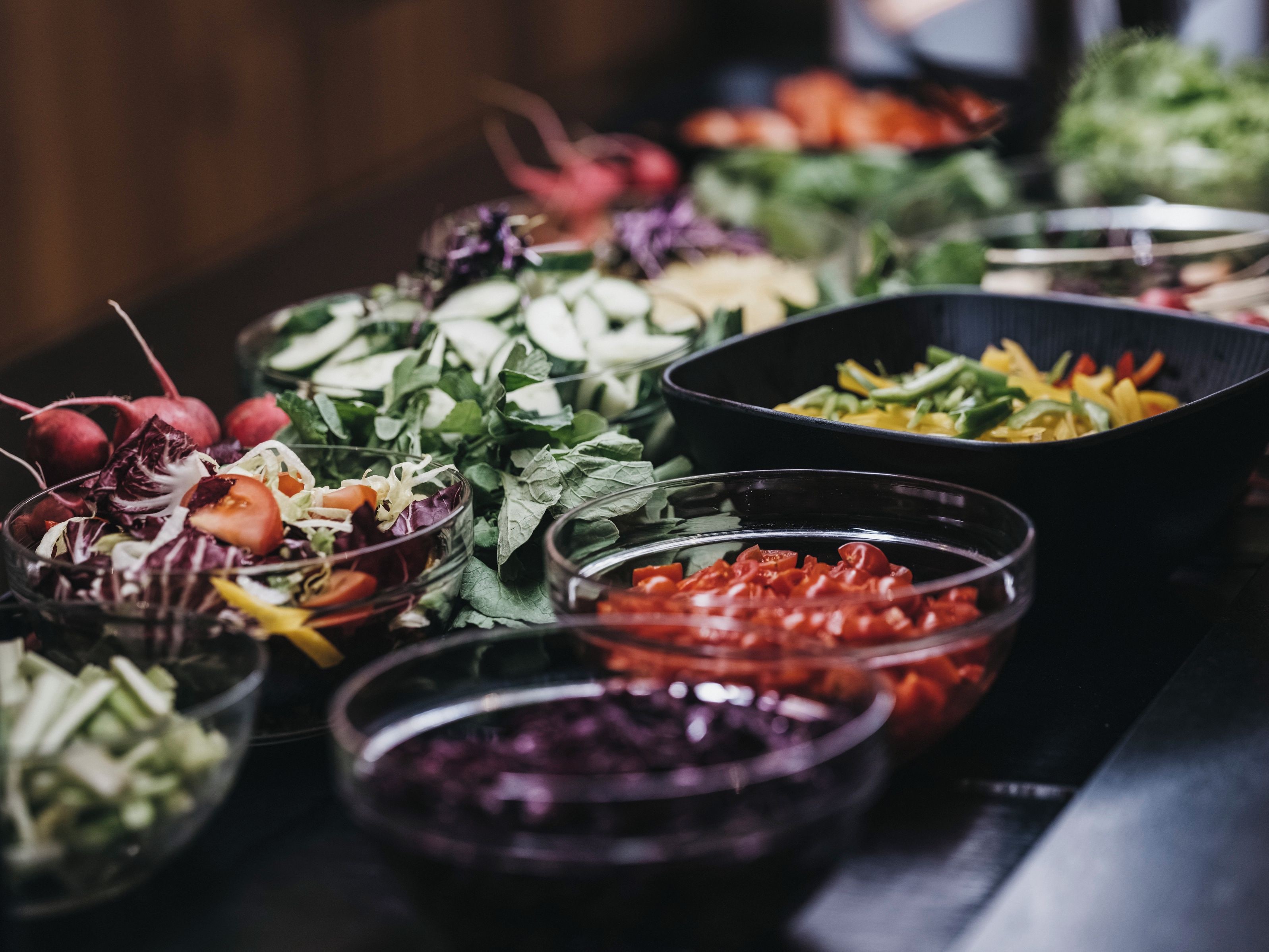 A variety of food items in bowls, including salads and vegetables.