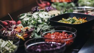 A variety of food items in bowls, including salads and vegetables.