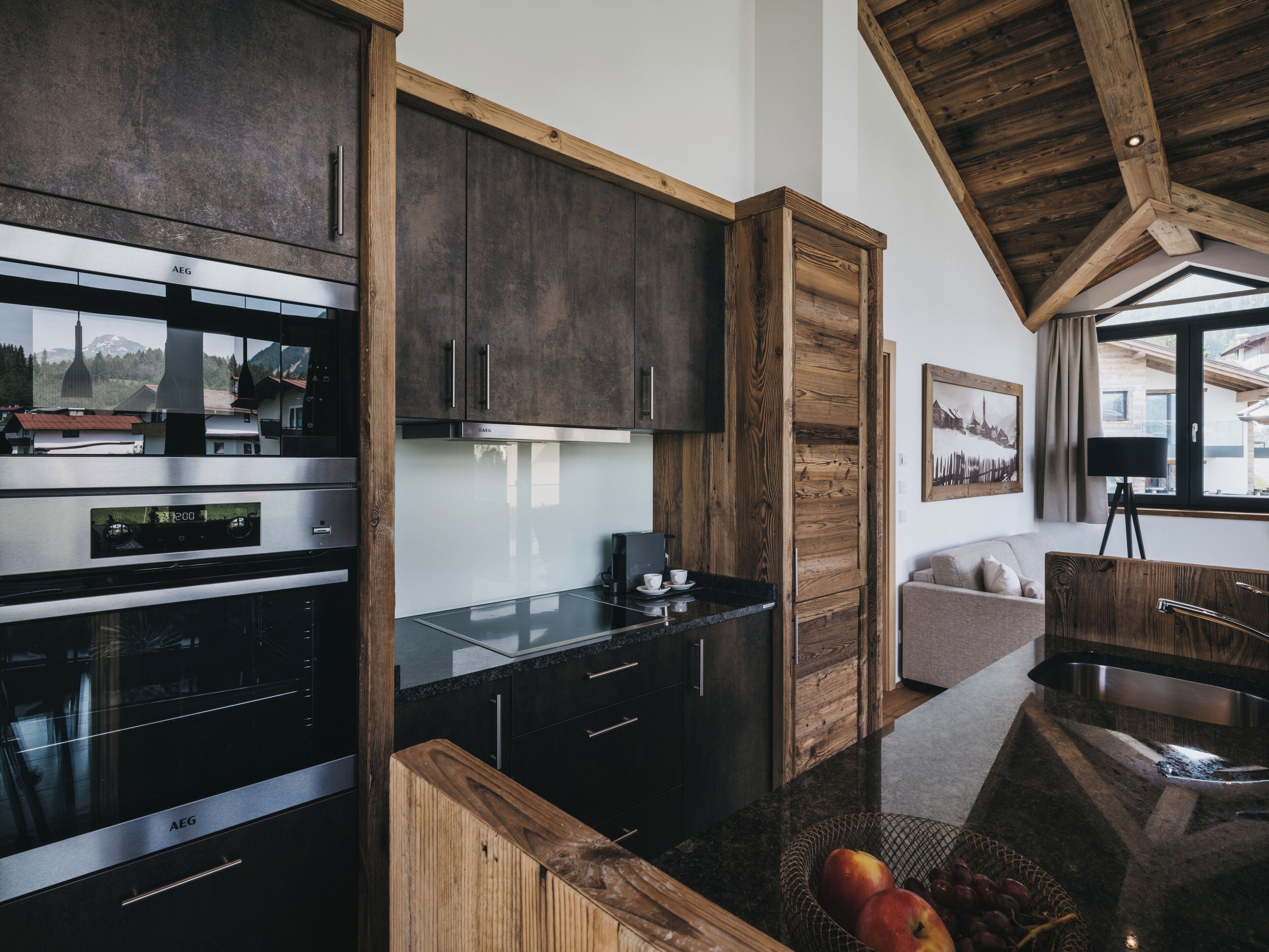 A modern kitchen with dark wooden cabinets, stainless steel appliances, and a wooden countertop.