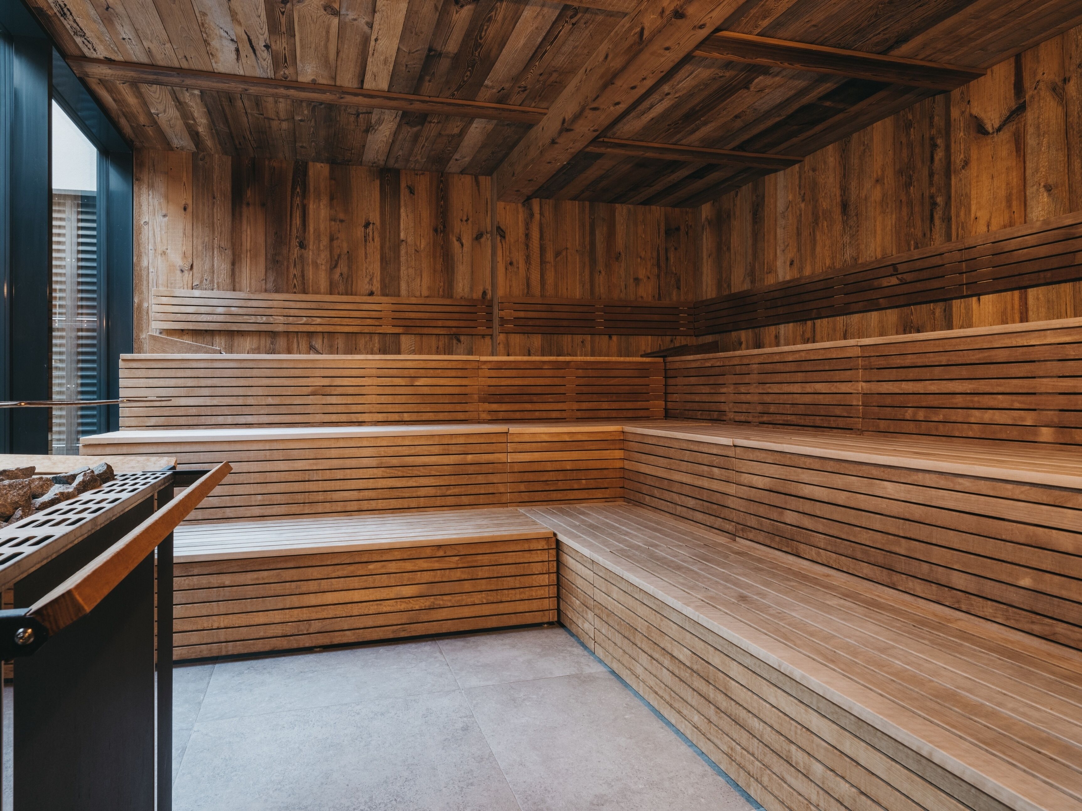 A sauna with wooden benches and a sloped ceiling.