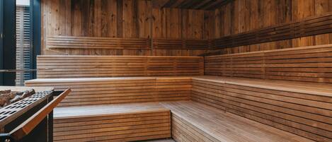 A sauna with wooden benches and a sloped ceiling.