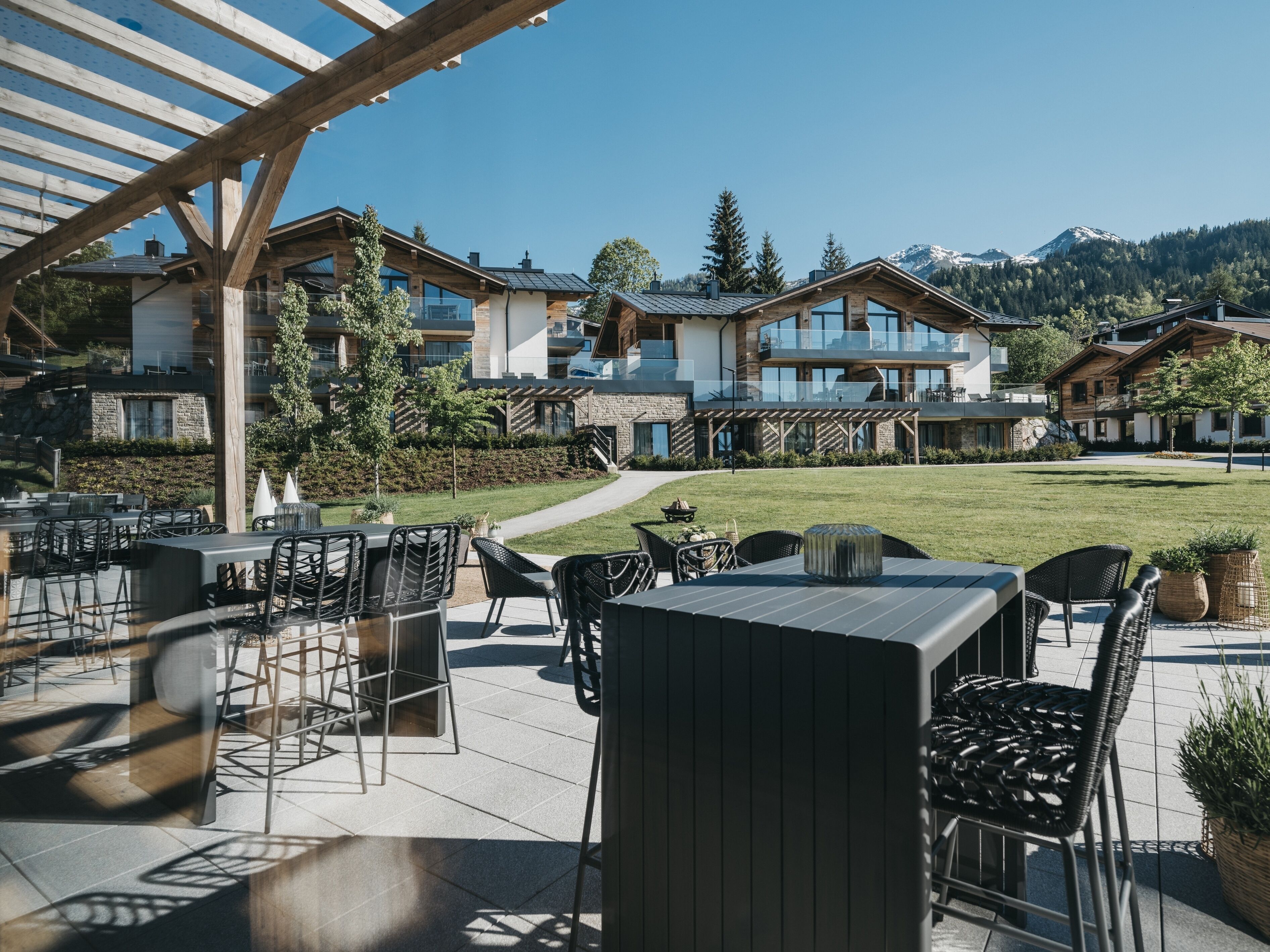 A patio area with outdoor seating, a pergola, and a view of a mountain range.
