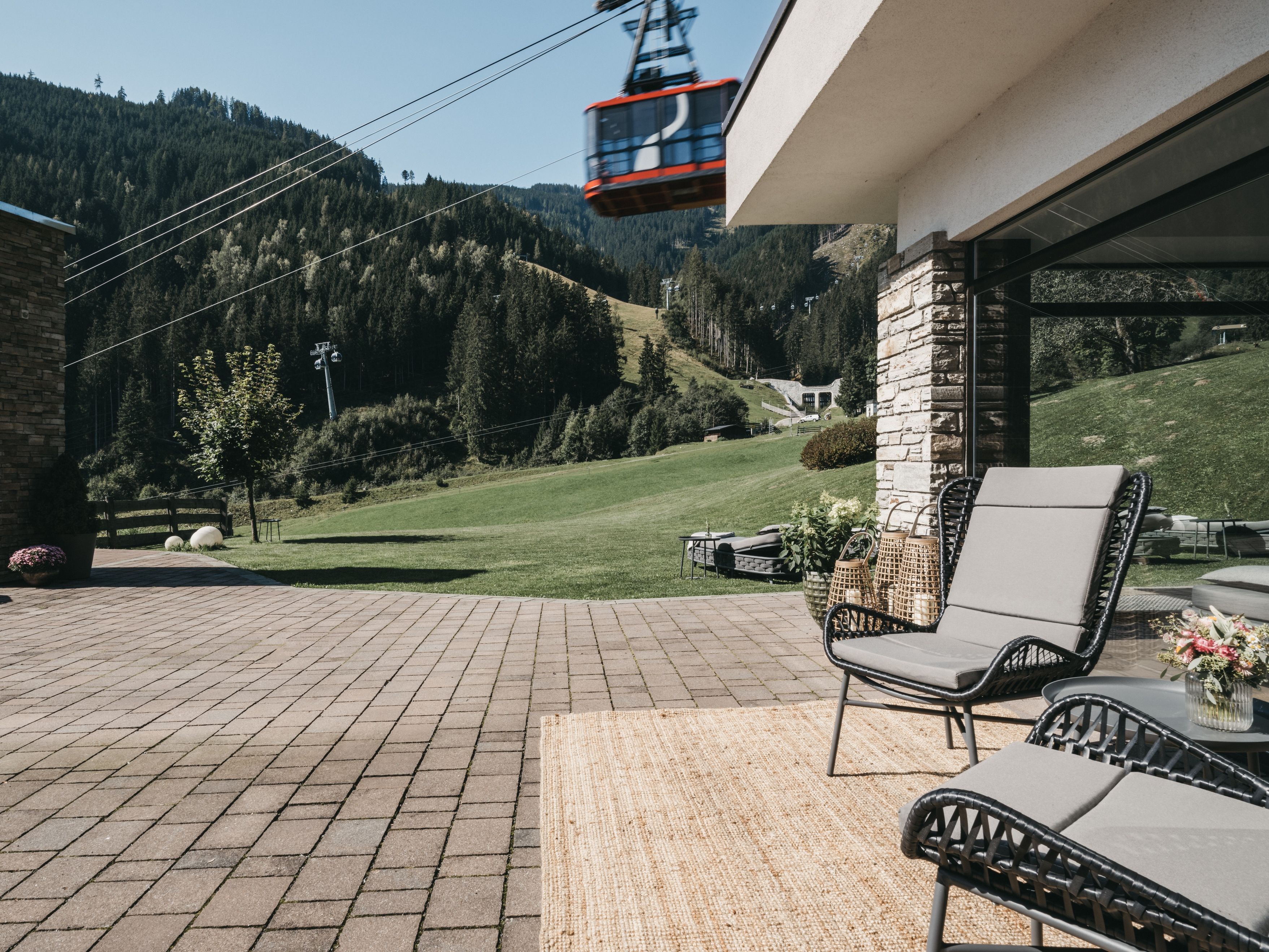 Un patio con mobili da esterno, un muro in pietra e vista su un paesaggio montano.