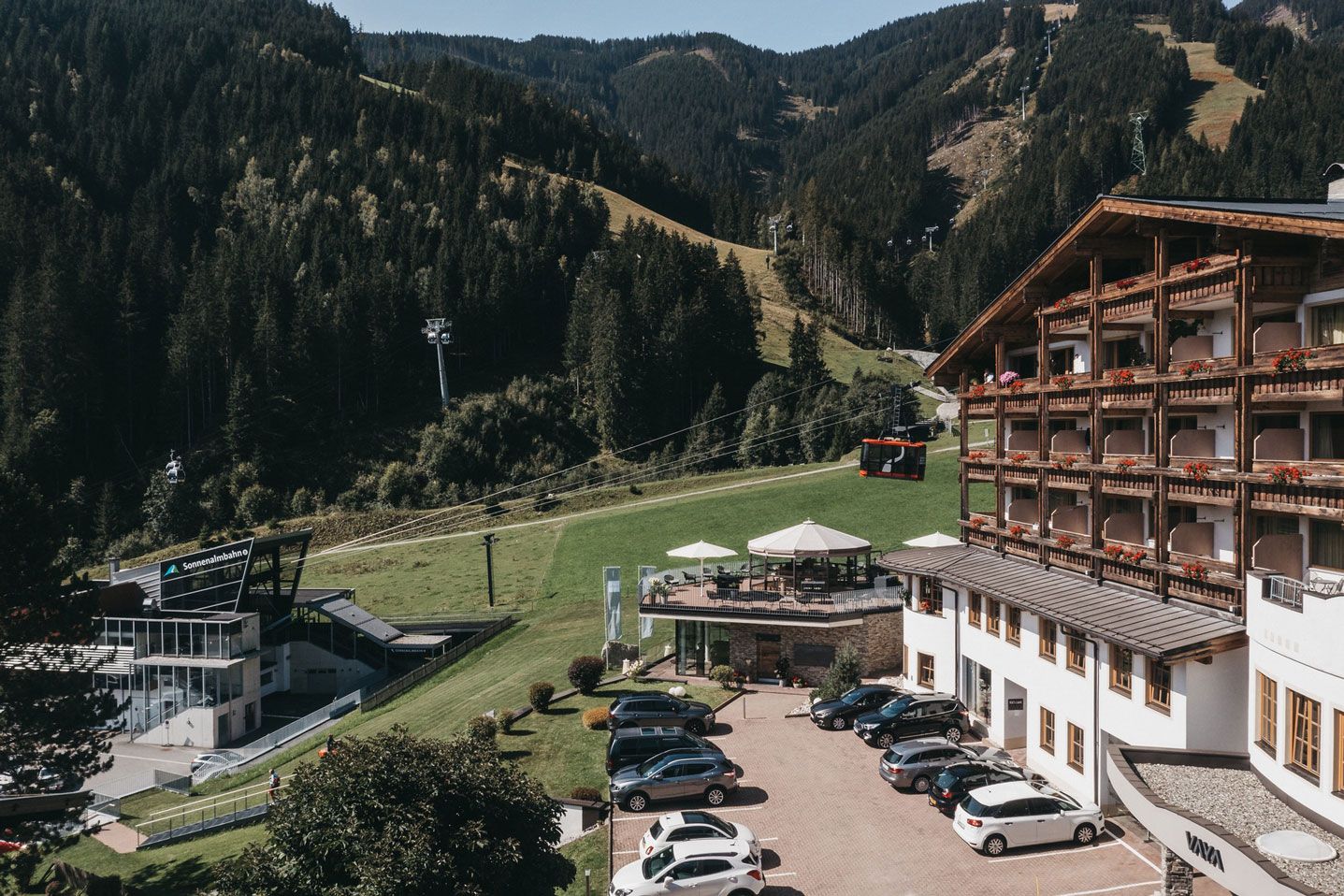 Una località montana con una seggiovia, un'area di parcheggio e un edificio con balconi.