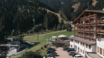 Una località montana con una seggiovia, un'area di parcheggio e un edificio con balconi.