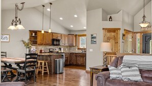 Una cocina amplia con armarios de madera, una isla central e iluminación colgante.