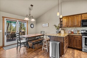 A kitchen with wooden cabinets, a granite countertop, and a stainless steel stove.