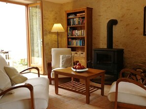 A cozy living room with a fireplace, a bookshelf, and a table with apples.