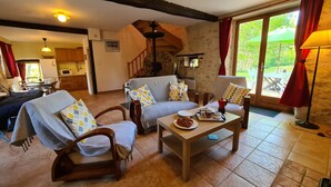 Un salon confortable avec un canapé, des fauteuils, une table basse et un coin repas comprenant une table et des chaises.