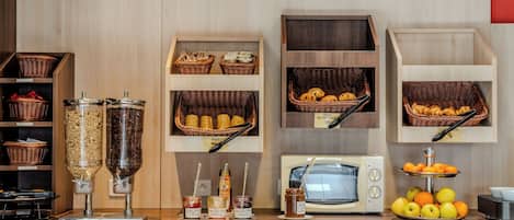 A breakfast buffet area with various food items and condiments.