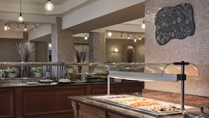 Un espace buffet proposant une variété de plats, un mur décoratif agrémenté d’un tableau noir et un éclairage moderne.