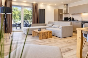 Una sala de estar moderna con un sofá, una mesa de centro y vistas al exterior.