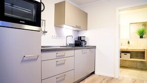 A modern kitchen with a built-in oven, a coffee machine, and a microwave. - Smart Resorts - Haus Saphir - Ferienwohnung 506 mit 2 Schlafzimmern, max (Winterberg)