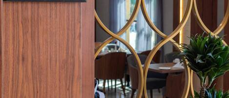 A sign for the Diamond Restaurant with a modern interior design, including a wooden partition and a geometric ceiling pattern.
