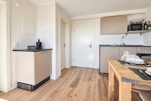 A compact kitchen with a built-in microwave, a coffee machine, and a small countertop. - Smart Resorts – Haus Opal – Holiday flat 405 with 1 bedroom, sleeps up to 4 (Winterberg)