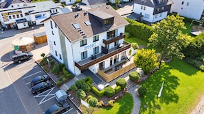 A multi-story building with a sign for 'Smart Resorts' and a parking lot with several cars. - Smart Resorts - Haus Azur - Ferienwohnung 805, Max. 5 Personen (Winterberg)