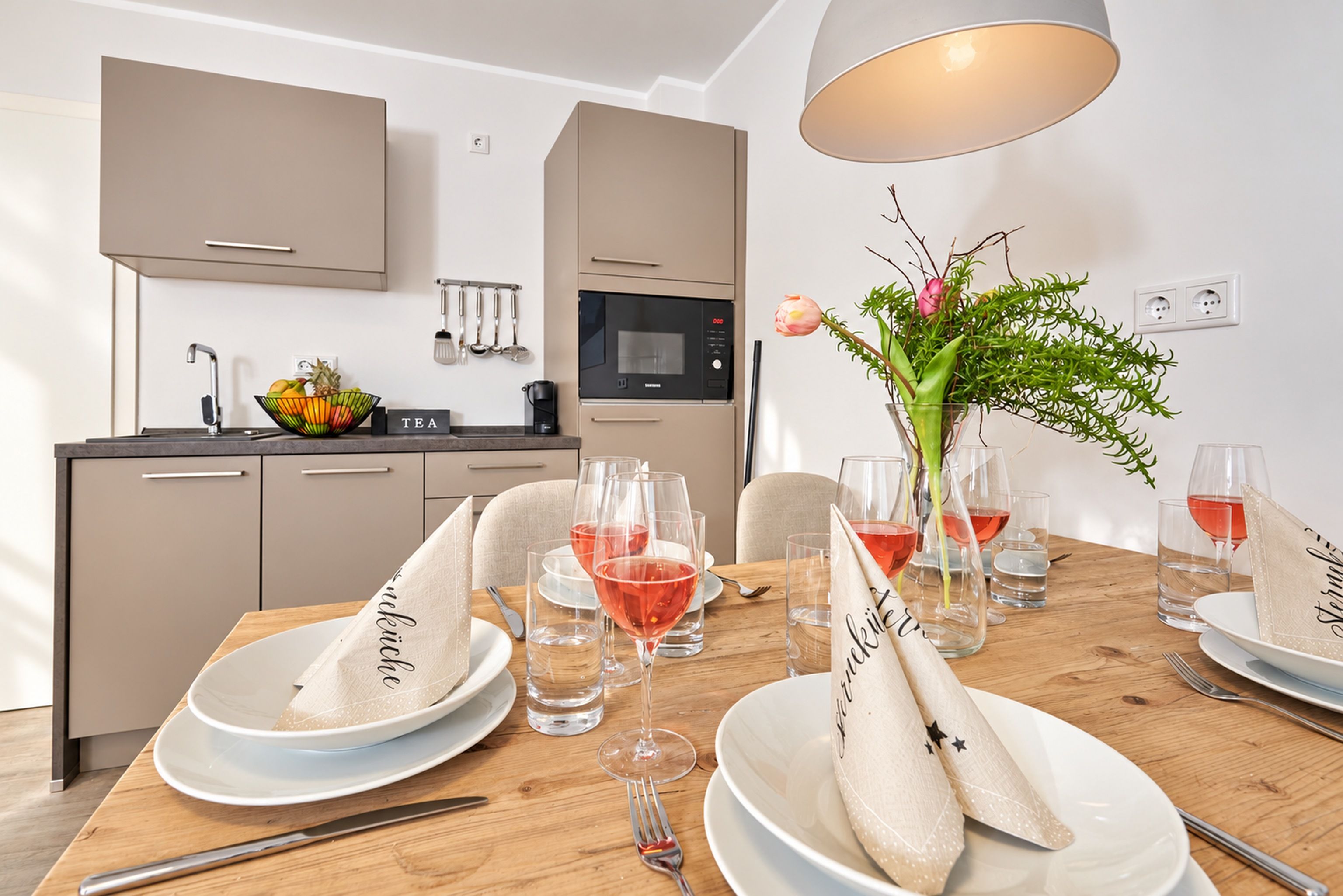 A modern kitchen with a dining area set for a meal.