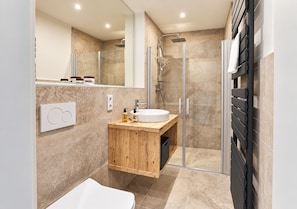 A modern bathroom with a wooden vanity, a glass shower enclosure, and a large mirror. - Smart Resorts - Maison Azur - Vacation Apartment 810, max. 4 people (Winterberg)