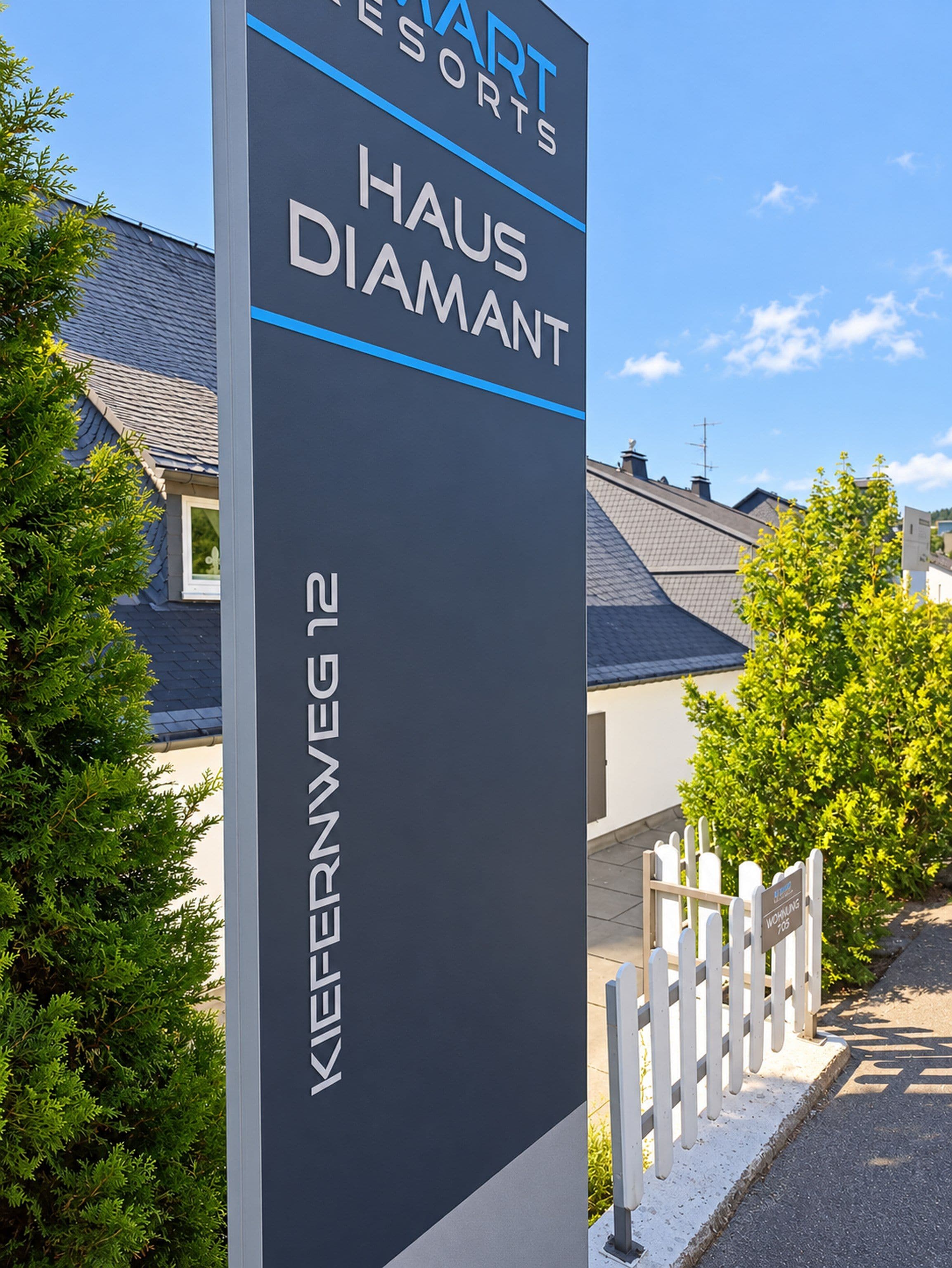 A sign for Haus Diamant, part of the Hart Resorts, with a clear view of the surrounding residential area.