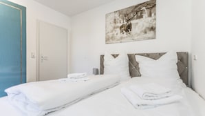 A hotel room with a bed, two pillows, a wall-mounted picture of a deer, and a door. - "Charming Getaway in Winterberg: Your Perfect Family Retreat Awaits!" (Winterberg)