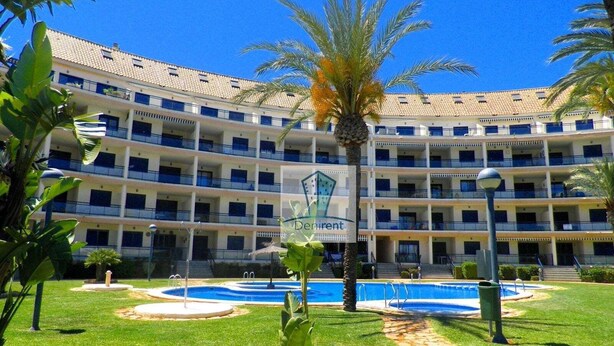 Un hôtel à plusieurs étages doté d’une piscine et de palmiers.