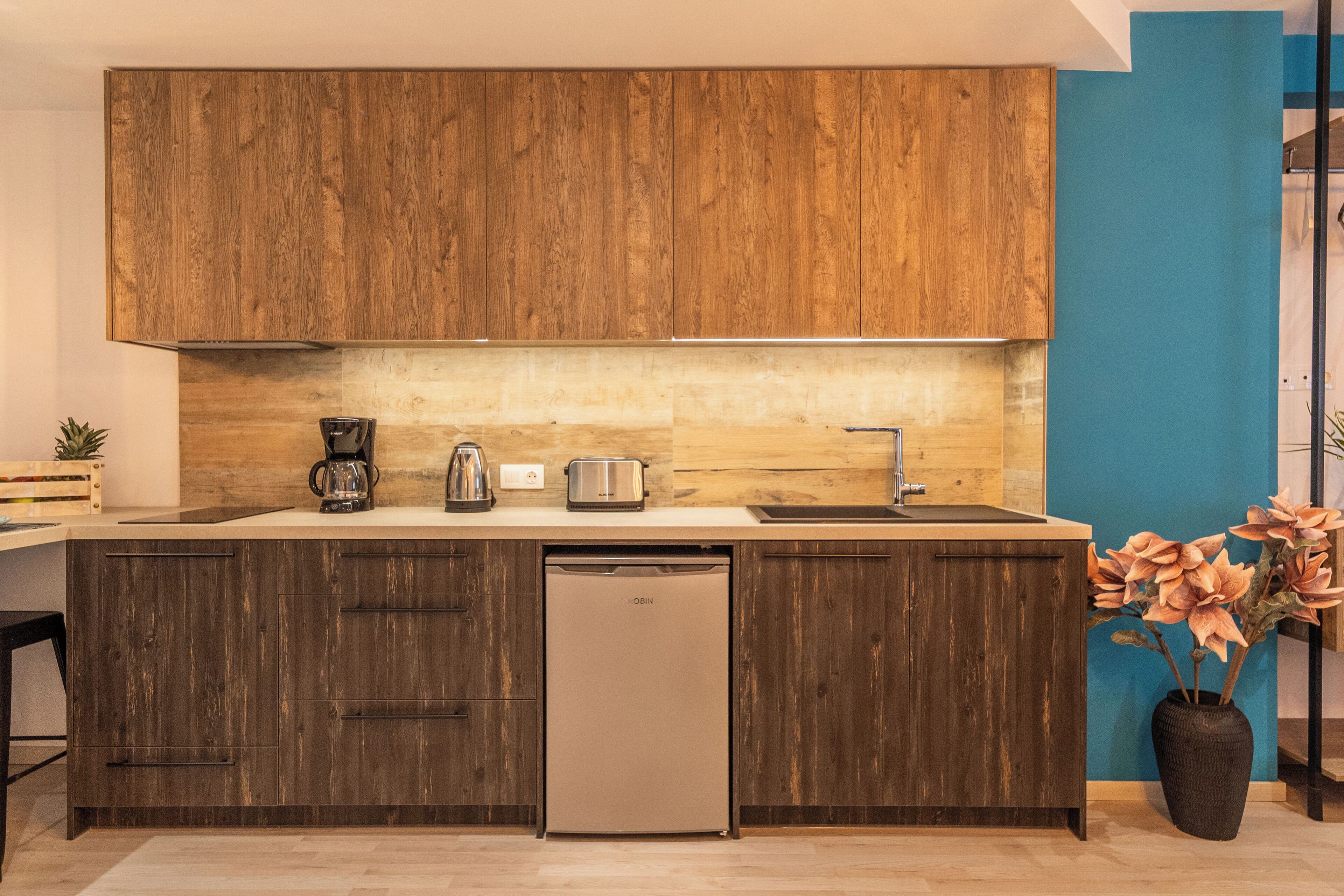 Een moderne keuken met houten kastjes, een vaatwasser en een spoelbak.
