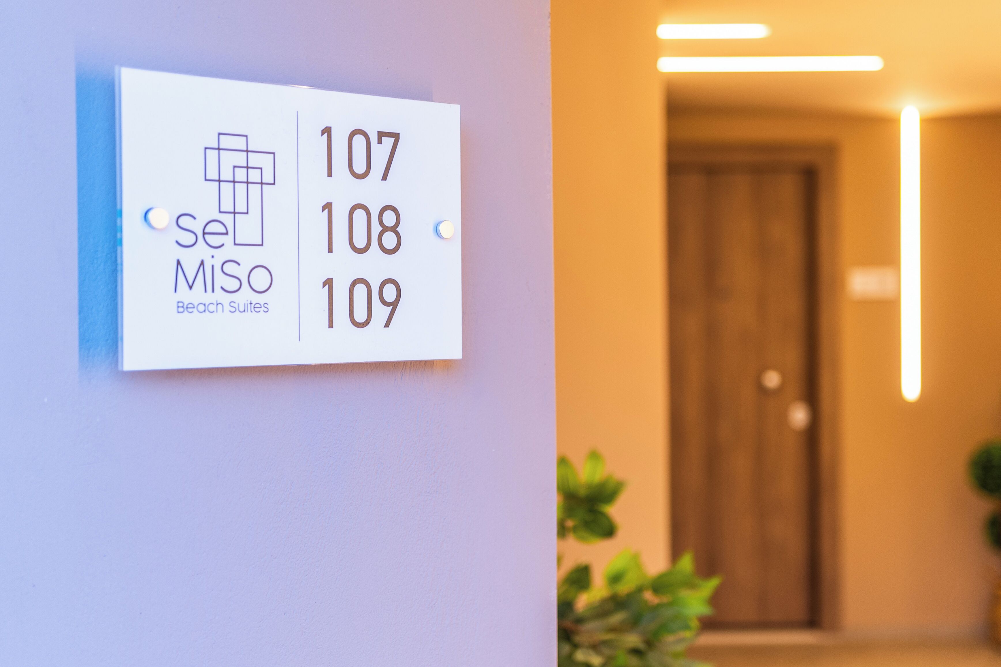 A hotel sign with room numbers 107, 108, and 109, and the name "SeMiso Beach Suites".