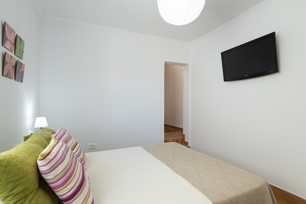 A bedroom with a bed, a TV mounted on the wall, and a staircase leading to another room. - Holiday home with terrace and sea views (Mogán)
