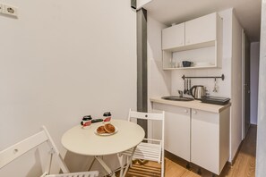 Economy kamer | Privékeuken | Een minikoelkast, een kookplaat, kookgerei, borden en bestek