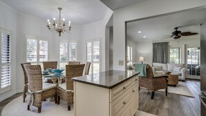 A spacious living area with a dining table, wicker chairs, a sofa, and a ceiling fan. - Get Free Night/See Description*Golf Cart*Nearby Pool*Cart To Beach,Baytowne,Pool (Miramar Beach)