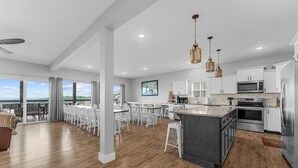A spacious kitchen with white cabinets, a large island, and a view to the outside. - Beautiful Lake Views, Indoor and Outdoor Pool, Private Hot Tub, and Game Room! (Branson)