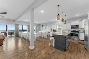 A spacious kitchen with white cabinets, a large island, and a view to the outside. - Beautiful Lake Views, Indoor and Outdoor Pool, Private Hot Tub, and Game Room! (Branson)