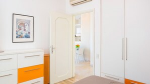 Une chambre à coucher comprenant un lit, une armoire, une commode et une porte donnant sur une salle de bain.