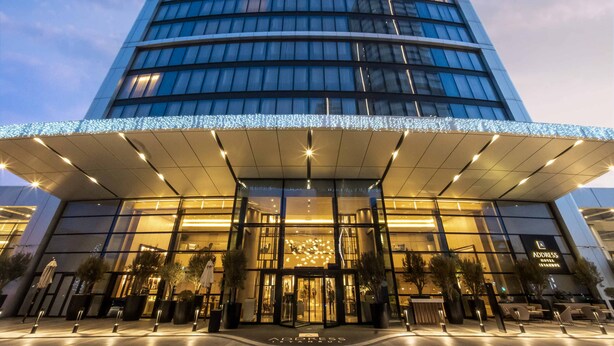 A modern hotel with a curved facade, large glass windows, and a prominent entrance with a covered walkway. - Address Istanbul (Istanbul)