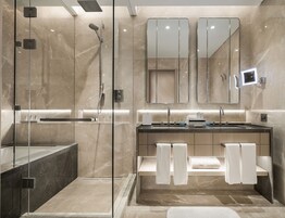 Un baño moderno con ducha envuelta en vidrio, un espejo grande y un mueble de tocador con lavabo y barra para toallas.