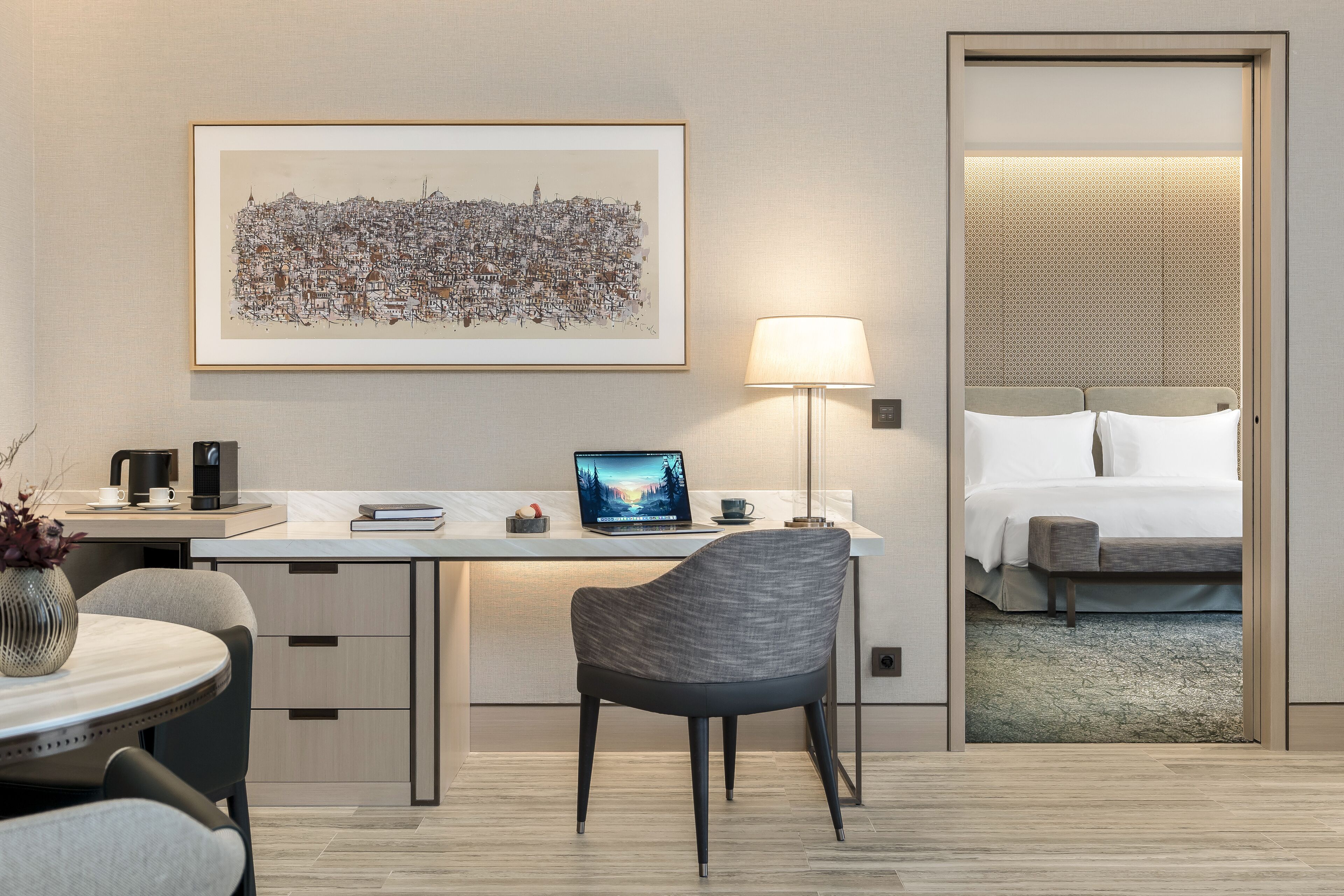 Habitación de hotel moderna con escritorio, computadora portátil, silla y cama.