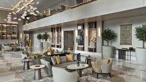 A spacious lobby with a high ceiling, modern furniture, and decorative lighting. - Address Istanbul (Istanbul)