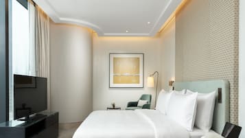 Ein modernes Hotelzimmer mit einem großen Bett, einem Fernseher, einem Schreibtisch und einer Wand mit Muster.