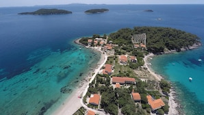 An aerial view of a coastal village with houses along the shoreline, clear blue waters, and small islands in the distance. - Awesome Home in Prizba With Wifi and 3 Bedrooms (Blato)