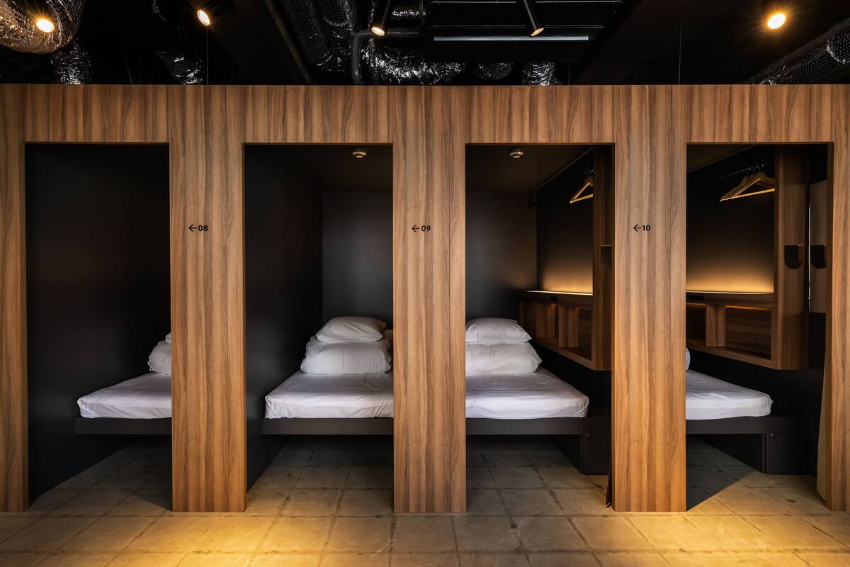Una fila de literas de madera con compartimentos individuales, cada uno identificado con un número.