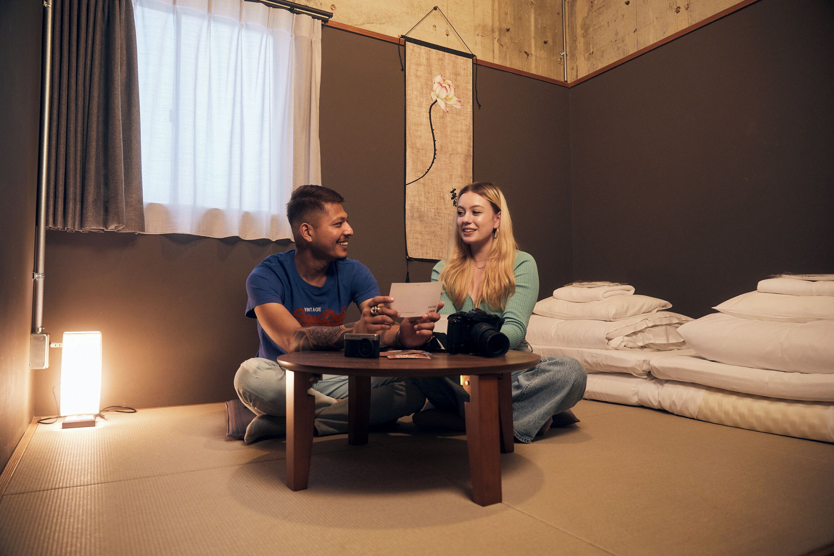 Una habitación con cama, una mesa y un ventanal con cortinas.
