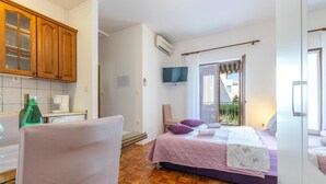 A bedroom with a bed, a chair, a TV, and a window with a view of the outside. - Stunning Apartment in Stobrec With Wifi (Split)