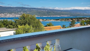 A balcony with a view of a coastal town, a clear blue sea, and distant mountains. - Awesome Home in Silo With Wifi and 2 Bedrooms (Dobrinj)