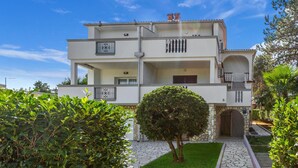 A two-story building with a central balcony, a stone entrance, and a small tree in the foreground. - Awesome Home in Silo With Wifi and 2 Bedrooms (Dobrinj)
