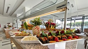Un bufé con diferentes opciones de comida y frutas frescas.