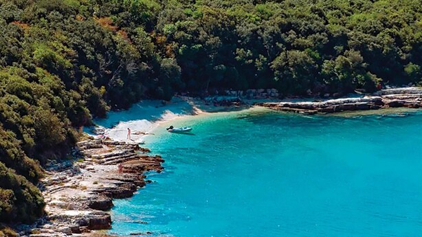 A coastal area with clear turquoise waters, rocky shorelines, and dense green forest. - Stunning Home in Medulin With Wifi and 2 Bedrooms (Medulin)