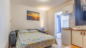 A compact room with a bed, a small table, a TV, and a kitchenette. - Stunning Home in Medulin With Wifi and 2 Bedrooms (Medulin)